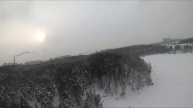 Buzlu bir gölün yakınındaki karlı bir ormanda FPV drone uçuşu, beyaz çam ağaçları, güzel manzaralar, sert soğuk kış, kuadkopter