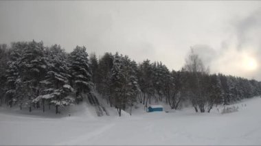 Buzlu bir gölün yakınındaki karlı bir ormanda FPV drone uçuşu, beyaz çam ağaçları, güzel manzaralar, sert soğuk kış, kuadkopter