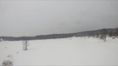Buzlu bir gölün yakınındaki karlı bir ormanda FPV drone uçuşu, beyaz çam ağaçları, güzel manzaralar, sert soğuk kış, kuadkopter