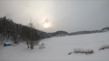 Buzlu bir gölün yakınındaki karlı bir ormanda FPV drone uçuşu, beyaz çam ağaçları, güzel manzaralar, sert soğuk kış, kuadkopter