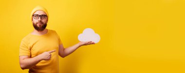 Zarif sakallı adam sarı arkaplan, depolama konsepti, metin için alanı olan panoramik yerleşim üzerindeki depolama bulutunu işaret ediyor