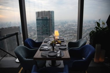 Gün batımında Moskova iş merkezinin panoramik manzaralı akşam yemeği. Şehrin arka planında akşam yemeği. Şehir merkezine bakan restoran. Romantik ortam, Moskova, Rusya