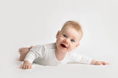 Beyaz elbiseli gülümseyen bir bebek.