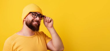 Sarı arka planda gülümseyen sakallı adam, panoramik düzen