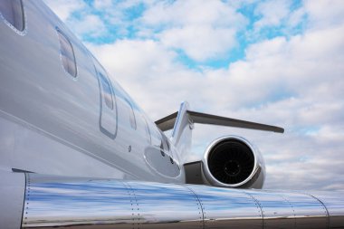 Modern özel jet uçağının bir parçası. Arka planda kuyruğu ve kanadı var.