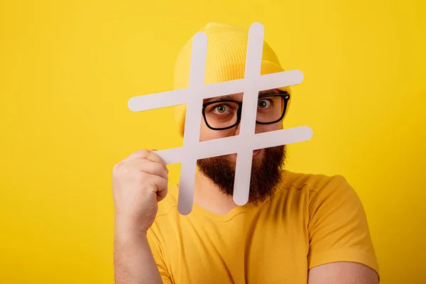 Stijlvolle Bebaarde Man Bril Zoek Naar Hashtag Gele Achtergrond — Stockfoto