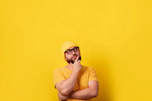 Pensive Man Zoek Naar Een Gele Achtergrond Met Ruimte Voor — Stockfoto