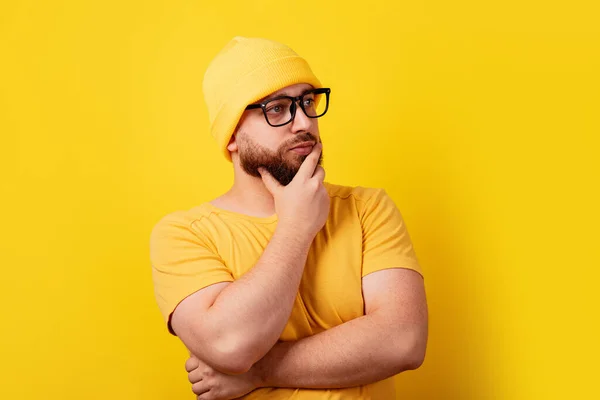 Hombre Barbudo Pensando Gafas Mirando Lado Sobre Fondo Amarillo —  Fotos de Stock