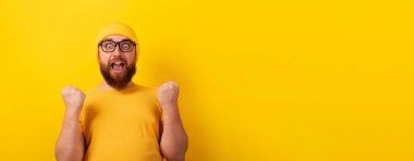 surprised winner man over yellow background, panoramic layout