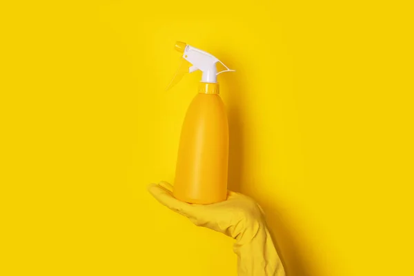 Sarı Arka Planda Sprey Şişesi Tutan Bir Eldiven Temizlik Kavramı — Stok fotoğraf
