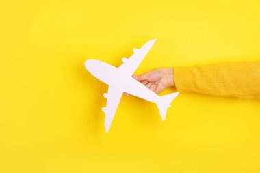 El ele tutuşarak sarı arka plan üzerinde beyaz uçak