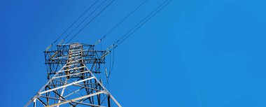 Mavi gökyüzü üzerinde yüksek voltajlı elektrik iletim kulesi, metin için alanı olan panoramik görüntü
