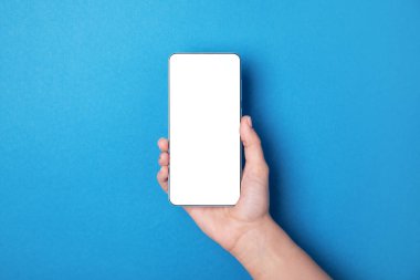 Mavi arkaplan üzerinde beyaz boş ekran ile el ele tutuşan cep telefonu, düzen resmi