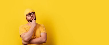 Düşünen adam sarı arka plana, panoramik düzene bakar.