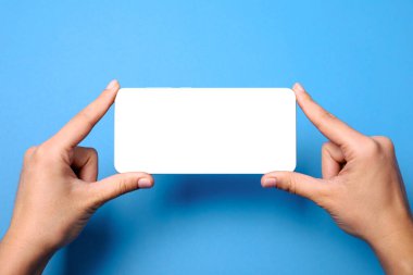 Mavi arkaplanda beyaz boş ekranlı cep telefonu, görüntünün düzeni