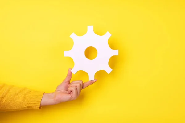 Hand Hält Getriebesymbol Über Gelbem Hintergrund — Stockfoto