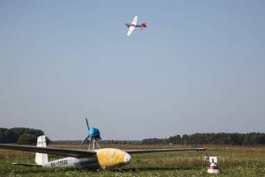 Tyumen, Rusya, 18 Ağustos 2016: Küçük uçakların pilotları çimlerden kalkan bir yaz sahasında gösteri uçuşları düzenliyor. Akrobaside aşırı yüklenme
