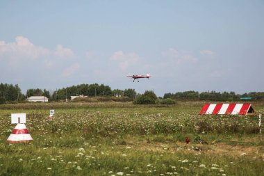 Tyumen, Rusya, 18 Ağustos 2016: Küçük uçakların pilotları çimlerden kalkan bir yaz sahasında gösteri uçuşları düzenliyor. Akrobaside aşırı yüklenme