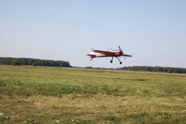 Tyumen, Rusya, 18 Ağustos 2016: Küçük uçakların pilotları çimlerden kalkan bir yaz sahasında gösteri uçuşları düzenliyor. Akrobaside aşırı yüklenme