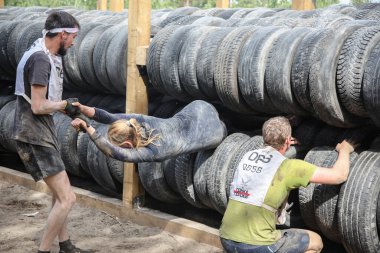 Tyumen, Rusya, 11 Haziran 2016: Hayatta kalma mücadelesi, takım engelli bir pistte koşuyor, yangın, çamur, su ve ahşap yapılar, yüksek duvar ve araba tekerleklerinin arasından rögar deliği