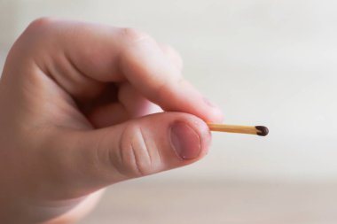 Çocuk bir kibrit tutuyor ve alevle yanıyor.