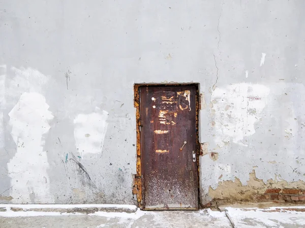 Eski bir kapı çatlak bir binaya erişim sağlar.
