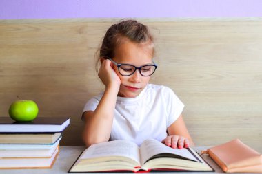 Liseli kız okuldan sonra çok şey öğrenmek için kitap okur.