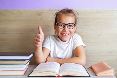 Liseli kız okuldan sonra çok şey öğrenmek için kitap okur.