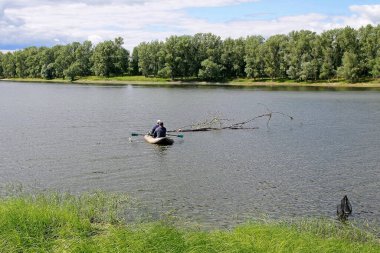 Sakin bir nehirde, şehrin telaşından uzakta balık tutmak.