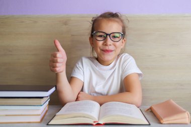 Liseli kız okuldan sonra çok şey öğrenmek için kitap okur.