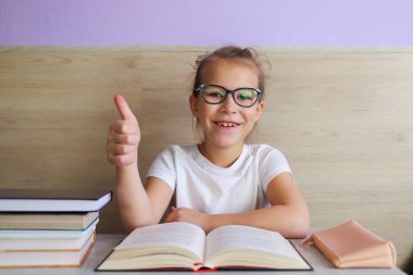 Liseli kız okuldan sonra çok şey öğrenmek için kitap okur.