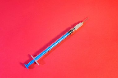 Beyaz bir geçmişi olan mavi bir maske ve sağlık çalışanları ve risk altındaki insanlar için enjeksiyon için bir şırınga. SARS-CoV-2 'ye karşı aşı ile tedavi. Boşluğu kopyala.