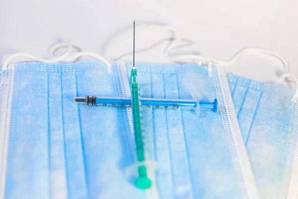 一种带有白色背景的蓝色面罩和注射器 用于医护人员和高危人群的注射 Sars Cov 2疫苗接种治疗 复制空间 — 图库照片