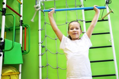 Küçük kız spor için çocuk merkezinde dar giysiler giyer ve sağlıklı bir hayat sürer.