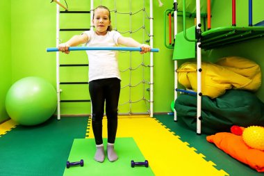 Küçük kız spor için çocuk merkezinde dar giysiler giyer ve sağlıklı bir hayat sürer.