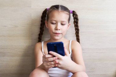 At kuyruklu kız telefonda konuşuyor, hücresel bağlantı üzerine ödev alıyor, tecrit ve salgın sırasında, uygun bir iletişim aracı.