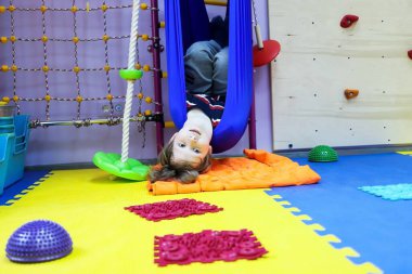 Çocuk çocuk çocuk özel ihtiyaçları ve düzeltmesi olan çocuklar için bir hamakta rehabilitasyon tedavisi görüyor otizm uçuş darbesi bağımsızlık öğreniyor.