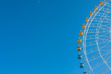 Mavi gökyüzünün altındaki dönme dolabın detaylı görüntüsü.