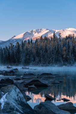 Çin 'in Xinjiang ilindeki Kanas Gölü' nün kış manzarası, gün doğumunda..