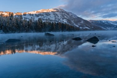 Çin 'in Xinjiang ilindeki Kanas Gölü' nün kış manzarası, gün doğumunda..