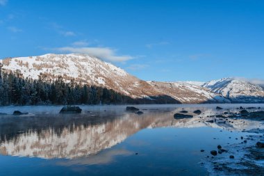 Çin 'in Xinjiang ilindeki Kanas Gölü' nün kış manzarası, gün doğumunda..