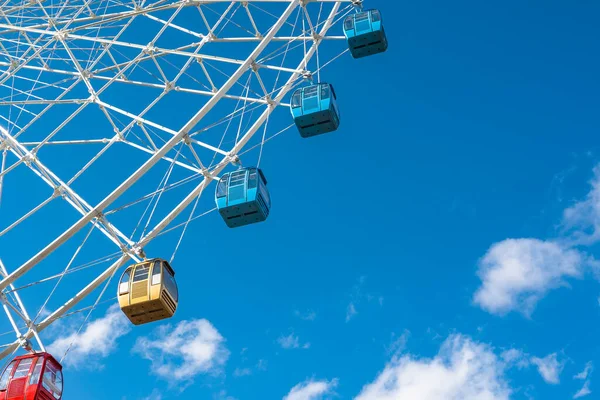 Mavi gökyüzünün altındaki dönme dolabın detaylı görüntüsü.