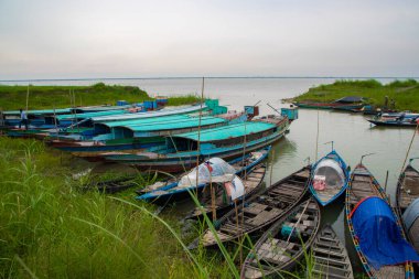 Bangladeş 'teki Padma nehrinin yeşil kıyısındaki birkaç ahşap balıkçı teknesinin güzel manzarası