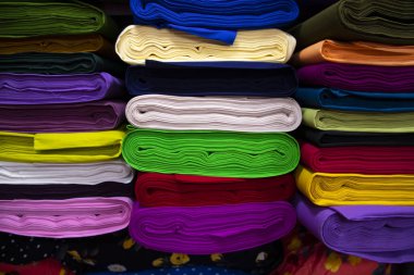 Artistic variety shade tone colors Textile Fabrics stacked on retail Shop Shelf to sale