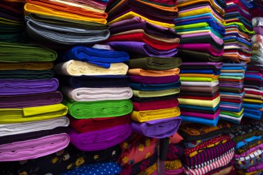 Artistic variety shade tone colors Textile Fabrics stacked on retail Shop Shelf to sale