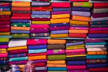 Artistic variety shade tone colors Saree's stacked on retail Shop Shelf to sale