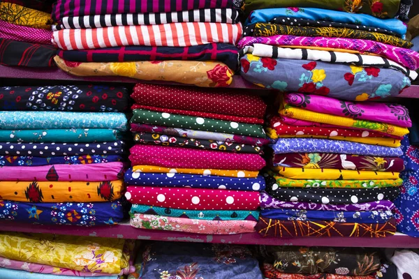 Artistic variety shade tone colors Textile Fabrics stacked on retail Shop Shelf to sale