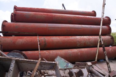 Paslanmış çelik metal borular endüstriyel bir alanı istif ediyor.