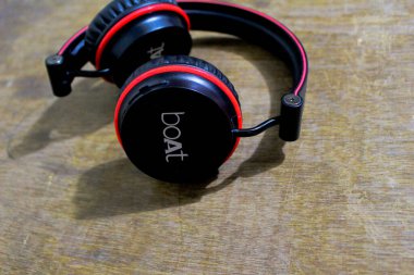 red and black colored headphone is lying there on cardboard,view