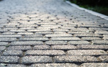 Kaldırım taşlarının arka planı. Kalıplı gri taşlar, yakın plan. Eski taş yol. Yumuşak odak.